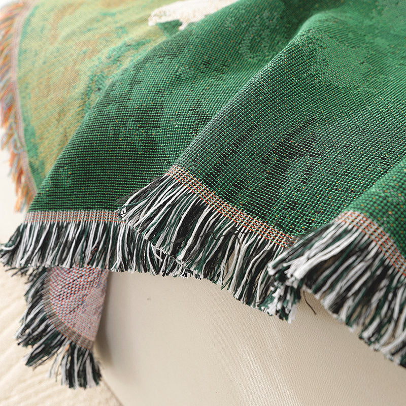 Timarno woven sheep throw blanket draped over a cream seat, showing green textured fabric and fringed edges.