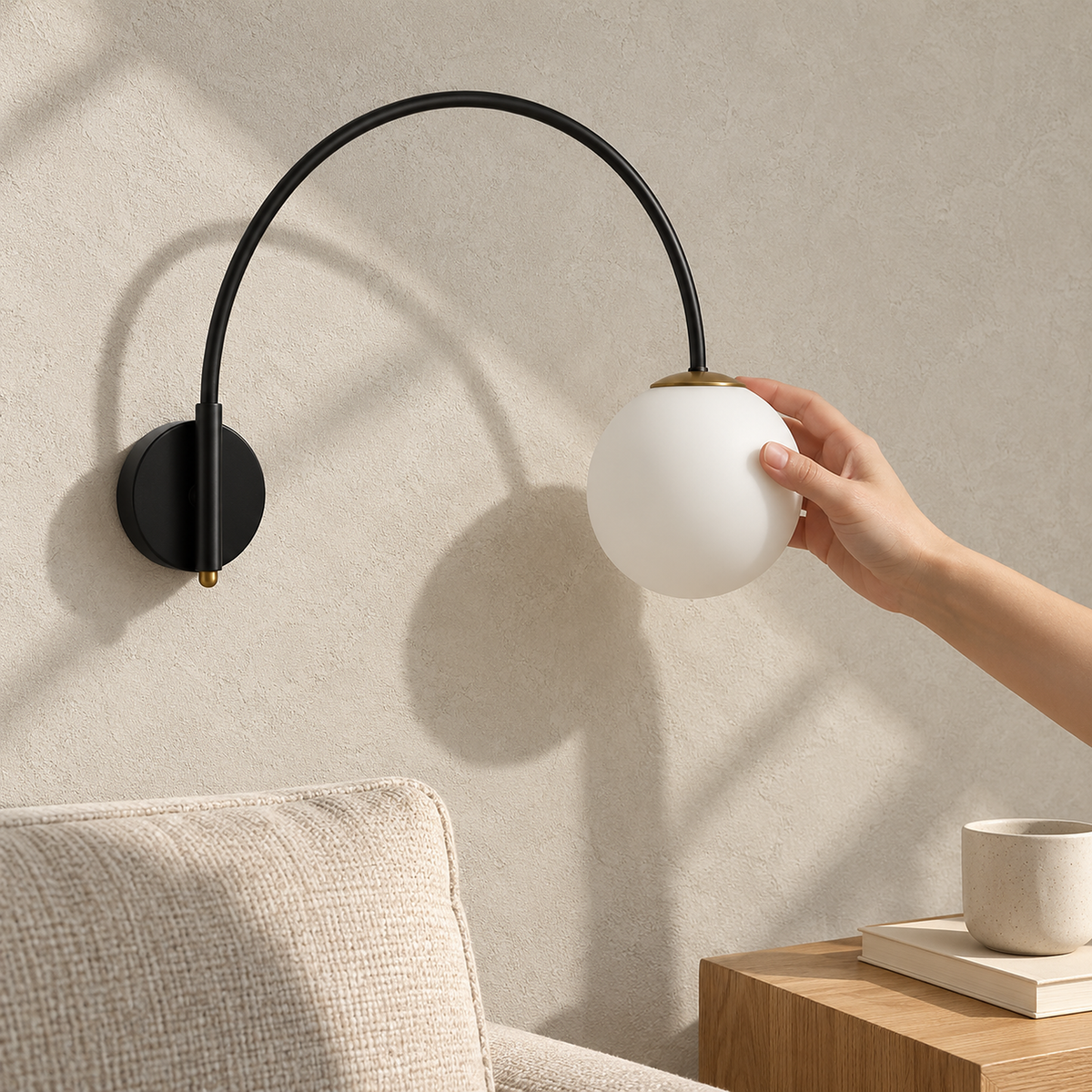 Tirsalo black and white plug in wall lamp, unlit, mounted above a sunlit living room sofa