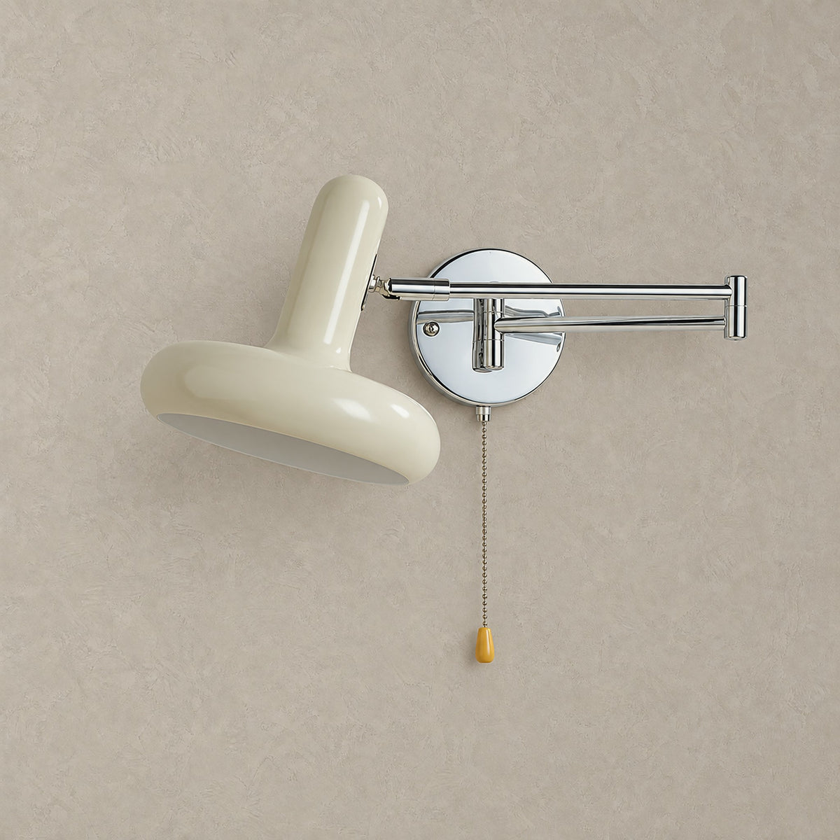 Tivenola swing arm wall sconce in cream, unlit on plaster with its round reflective silver backplate