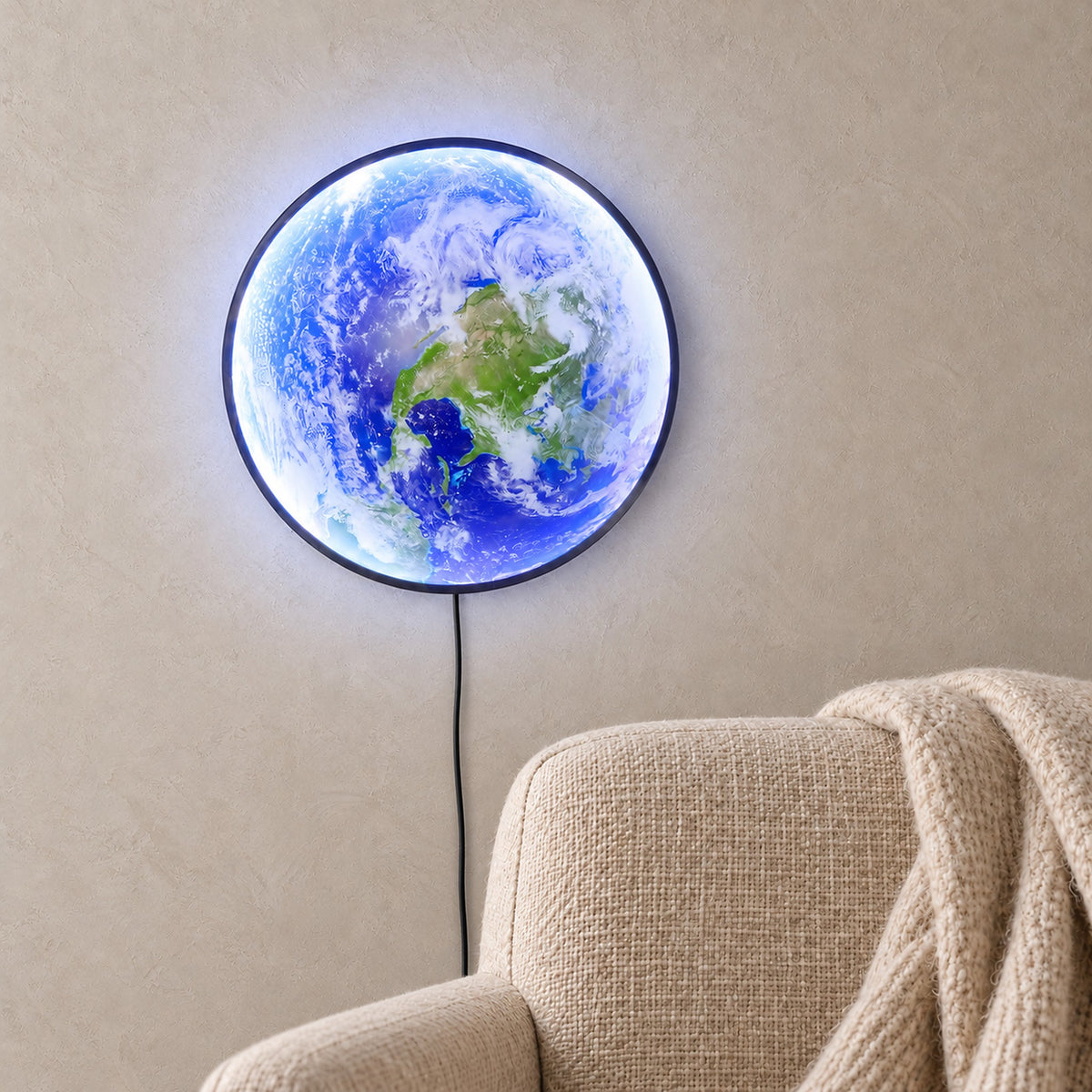 Tolanvi earth wall light in blue earth and dark rim, a plug in wall sconce glowing above an oatmeal armchair