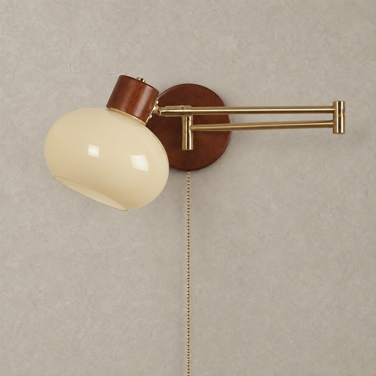 Tolvaren cream plug in wall sconce unlit on plaster, with a gold colored arm and walnut base #color_cream