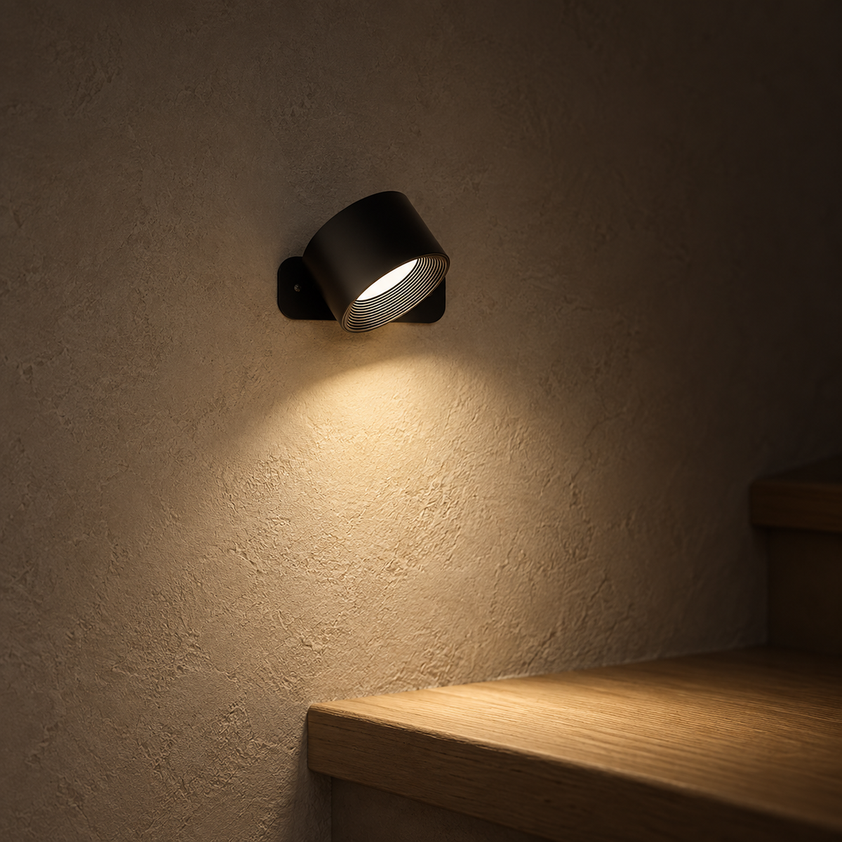 Tomelira black cordless wall lamp pair tilted to direct warm light along stairway plaster at night