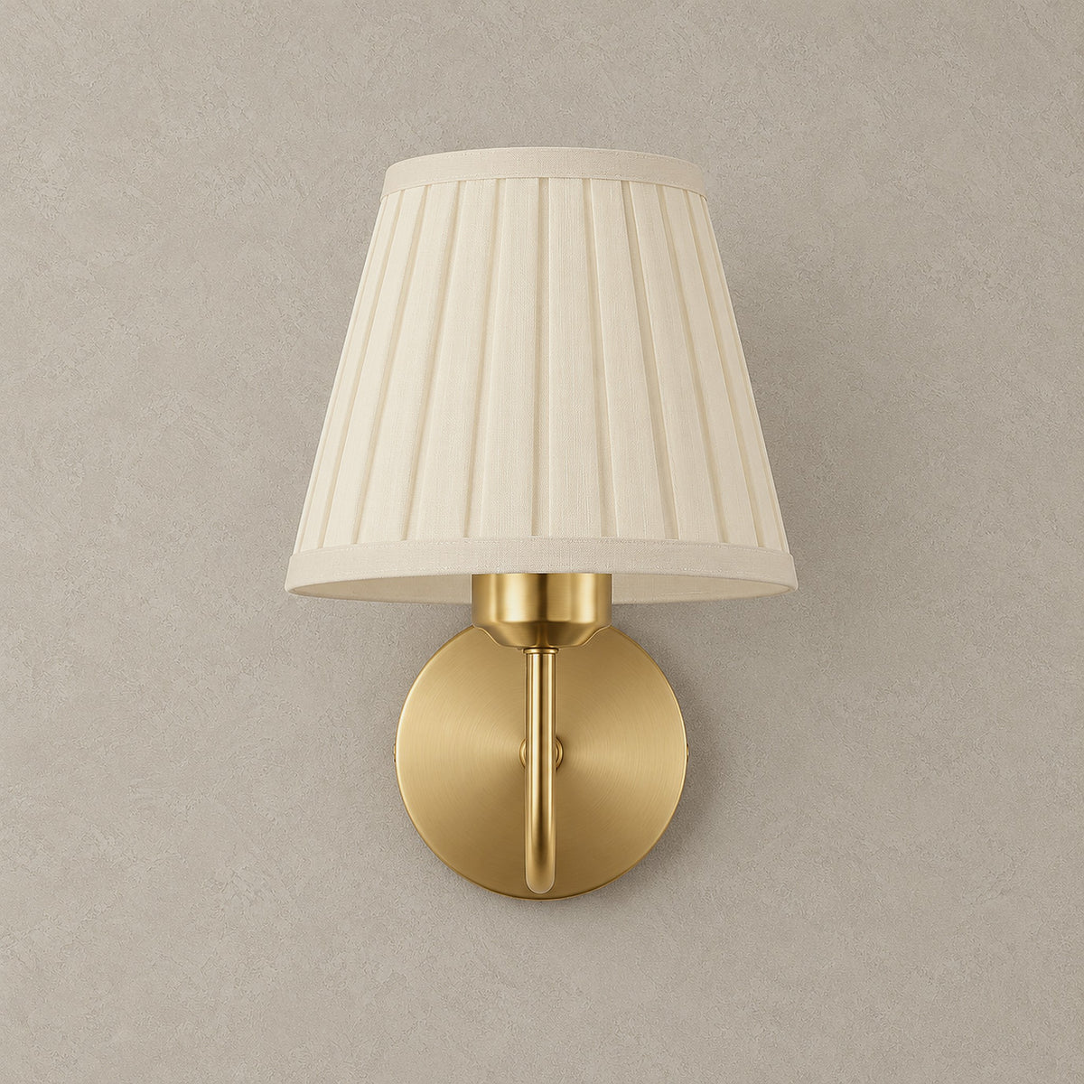 Tomirel gold rechargeable wall sconce, unlit, with a pleated fabric shade on a greige plaster wall