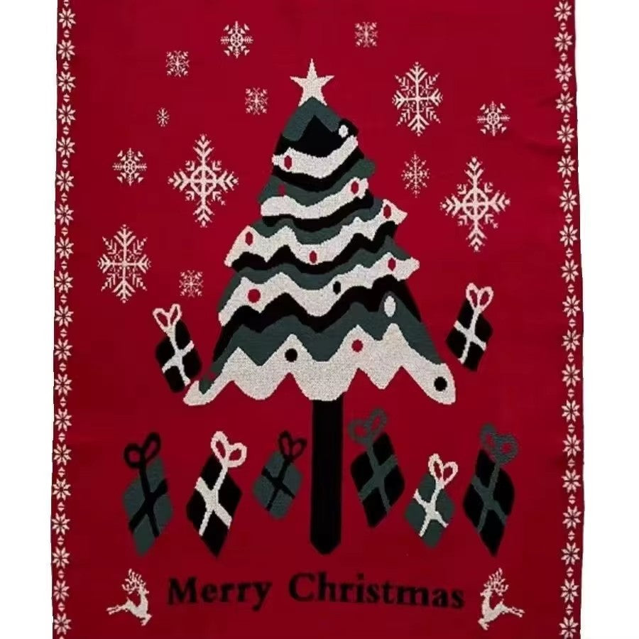 Velimoro christmas knit throw blanket laid flat, showing a tree, gifts, snowflakes and Merry Christmas on red.