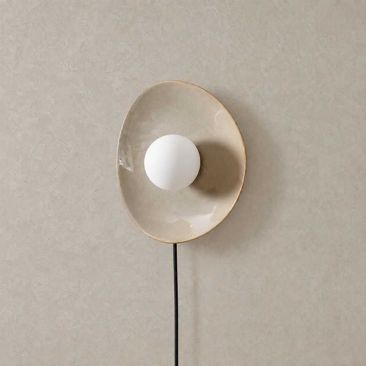 Venalti taupe plug in wall sconce shown unlit against plain plaster