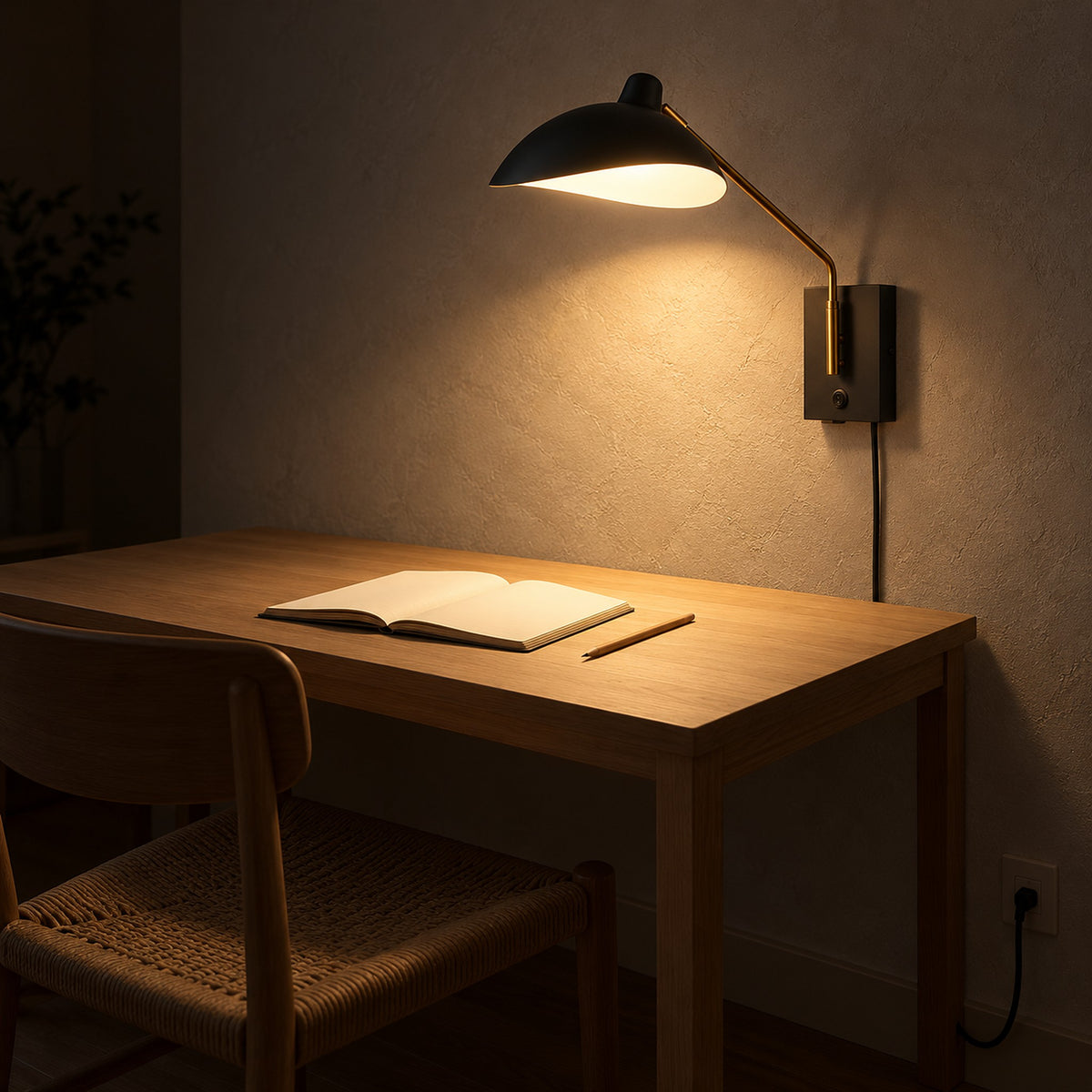 Vimolen black adjustable wall sconce that doubles as a bedside lamp, shown lighting a home office desk at night
